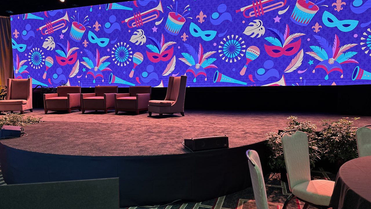 Empty gala stage with large Mardi Gras LED wall and panel seating