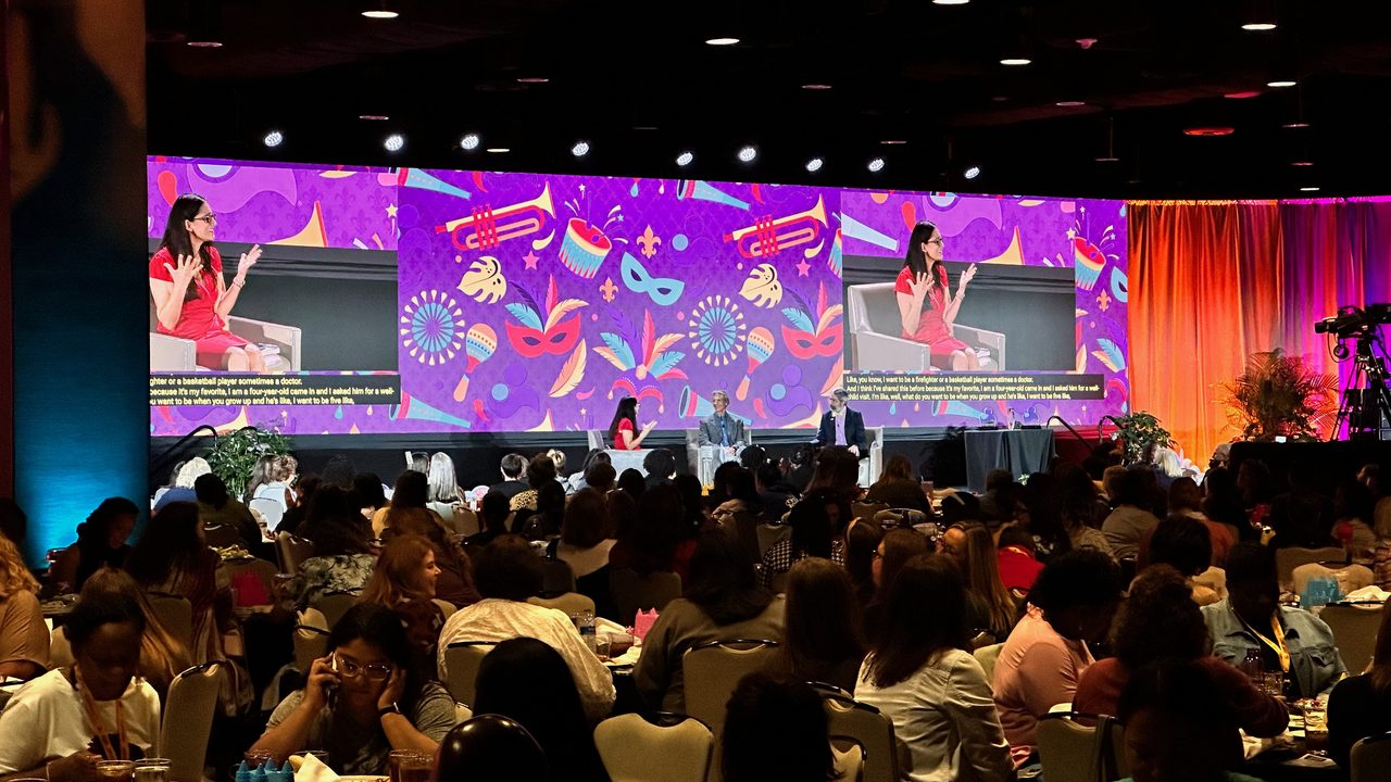 Mardi Gras gala with vibrant purple LED wall and full ballroom of guests